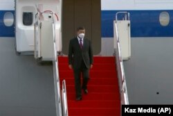 中国领导人习近平抵达哈萨克斯坦戴着口罩走下飞机。(2022年9月4日)