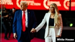 唐纳德·特朗普总统与埃丽卡·科克一同登上亚利桑那州格伦代尔州立农业体育场举行的查理·科克追悼会讲台。(白宫照片,2025年9月21日)