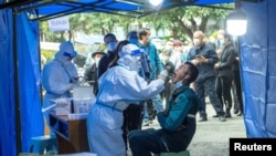 2021年11月3日人们在成都被封锁的住宅区附近排队做核酸检测