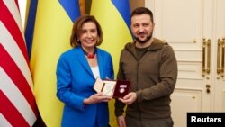 Президент України Володимир Зеленський нагороджує спікерку Палати представників Конгресу США Ненсі Пелосі орденом княгині Ольги під час візиту американських законодавців до Києва, 30 квітня 2022. Офіс президента України/REUTERS