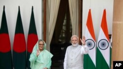 印度总理莫迪和孟加拉国总理谢赫·哈西娜(Sheikh Hasina)在会谈前向等待的媒体挥手致意。(2022年9月6日)