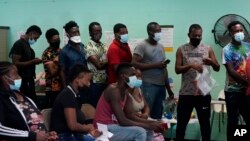 资料照片:在德克萨斯州德尔里奥的一个暂托中心,非法越过美墨边境并自首的移民获得援助。(2021年6月16日)