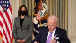 美国副总统哈里斯站在总统拜登身后参加一项行政令签署活动(2021年1月26日)