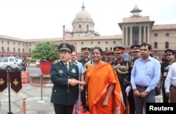 中国国防部长魏凤在新德里与印度国防部长西塔拉曼握手(2018年8月23日)