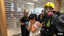 有市民不知道警方在德福花园商场施放催泪弹驱散示威者,被催泪烟波及,双眼刺痛,由示威者护送到安全地点 (摄影:美国之音汤惠芸)