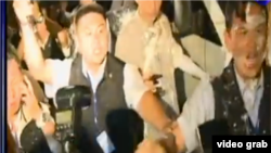 保护张志军的安全人员身上都是抗议群众泼洒的白漆(视频截图)