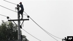 ရန်ကုန်မြို့က ဓာတ်အားပေးလျှပ်စစ်မီးတိုင် ပြုပြင်နေစဉ်။