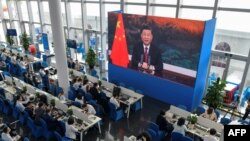 采访博鳌论坛的记者们在媒体厅观看屏幕上显示的中国国家主席习近平在开幕式上讲话。(2021年4月20日)