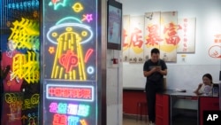 资料照:一名男子在北京一家商场的彩票店铺里购买彩票。(2024年7月13日)