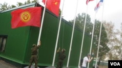 中亚国家经常与中国和俄罗斯共同参加一些活动。2014年在莫斯科郊外的军事比赛活动中,俄罗斯军人升中国和吉尔吉斯国旗。(美国之音白桦拍摄)