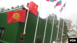 中亚国家经常与中国和俄罗斯共同参加一些活动。2014年在莫斯科郊外的军事比赛活动中,俄罗斯军人升中国和吉尔吉斯国旗。(美国之音白桦拍摄)