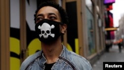 美国纽约,一名男子戴着带有骷髅头图案的防护口罩在曼哈顿市中心散步(2020年3月20日)。
