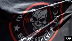 Фото: Прапор із логотипом приватної групи найманців Вагнера біля імпровізованого меморіалу перед офісом ПВК в Новосибірську, 24 серпня 2023 року.