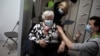 A woman receives a dose of the AstraZeneca COVID-19 vaccine at the Vaccine Village in Antwerp, Belgium on Tuesday, March 16, 2021. Belgium on Tuesday reaffirmed its support to AstraZeneca vaccines and said it will keep using it in its current…