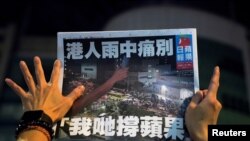 一名苹果日报的支持者手拿最后一期的苹果日报(路透社2021年6月24日)