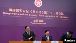 资料照:香港特首 李家超(中)率领律政司司长林定国(左)及保安局局长邓炳强2024年1月30日召开记者会,正式宣布展开为期29日的《基本法》23条立法公众咨询。 (美国之音/汤惠芸)