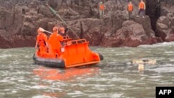 资料照片: 2024年3月14日台湾海警队成员(橙色头盔)与中国海警队参与联合搜救中国倾覆渔船