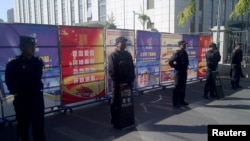 Policemen in riot gear guard a checkpoint on a road near a courthouse where ethnic Uighur academic Ilham Tohti's trial is taking place in Urumqi, Xinjiang Uighur Autonomous Region, Sept. 17, 2014.