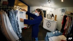 5月9日,科罗拉多州丹佛市准许商店重新开门营业。店员斯塔克整理商品,店主莫利在柜台忙碌。