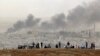 在叙土边界的叙吕奇郊外，人们站在山坡上观看叙利亚科巴尼的战火硝烟。（2014年10月13日）