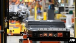 资料照:2022年9月20日,电池等待安装在福特汽车公司位于密歇根州迪尔伯恩的Rouge 电动汽车中心生产的F-150 Lightning卡车的车架上。