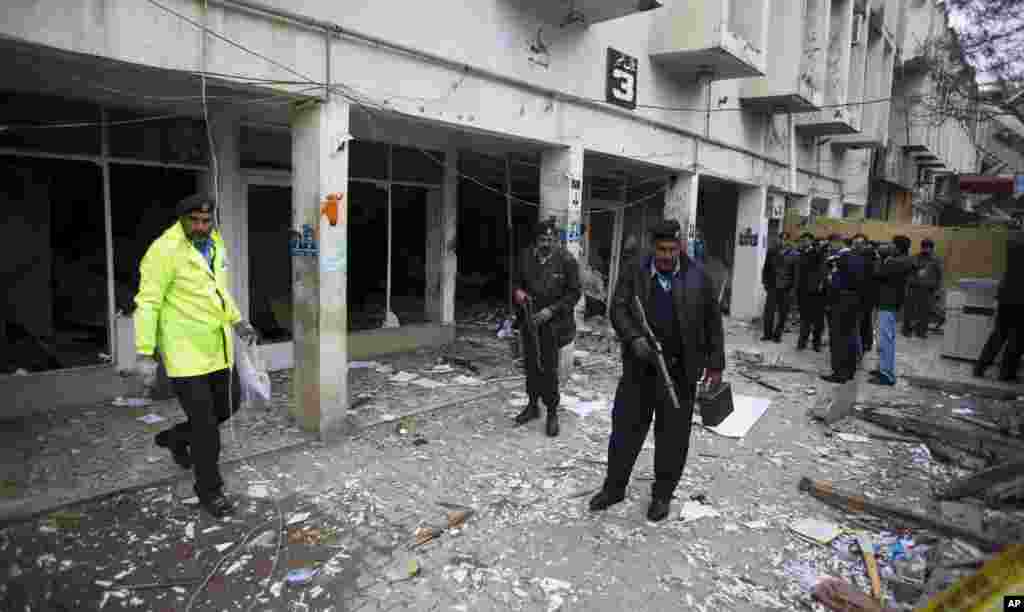 Police officers look for evidence at the site of a suicide attack in a court complex, Islamabad, March 3, 2014.