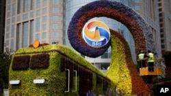 工人们在北京修建火车形状的花草,宣传即将召开的“一带一路”高峰论坛(2019年4月23日)