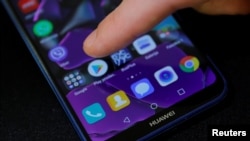 一名男子的手指正要点击华为手机上的谷歌应用程序商店。(2019年5月20日)