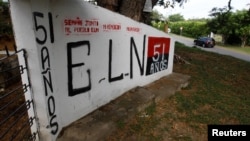 FILE - A graffiti, of rebel group Army Liberation National (ELN) is seen at the entrance of the cemetery of El Palo, Cauca, Colombia, Feb. 10, 2016.