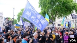 2022年6月4日在伦敦举行的六四事件纪念集会上,来自香港的示威者手持“光复香港,时代革命”的旗帜与支持乌克兰的示威者一起集会。 (美国之音/郑乐捷)