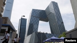 人们在北京的央视大楼旁排队等候进行新冠核酸检测。(2022年5月18日)