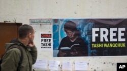 印度达兰萨拉的一名西藏流亡者走过一面要求释放扎西文色的横幅海报(2017年2月27日)