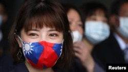 台湾桃园一家制造用于防疫口罩的医用无纺布工厂的职工戴着印有台湾旗帜的口罩。(2020年3月30日)