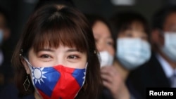 台湾桃园一家制造用于防疫口罩的医用无纺布工厂的职工戴着印有台湾旗帜的口罩。(2020年3月30日)