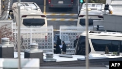 尹锡悦官邸安全人员在入口处检查车辆;公调处正着手准备第二次的逮捕行动。(法新社:2025年1月8日)