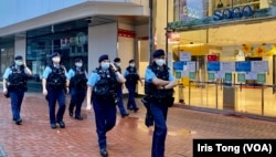 今年7-1刺警案一周年,大批穿上防刺背心、苛枪实弹的军装警员在事发地点铜锣湾崇光百货正门外巡逻。 (美国之音 汤惠芸)