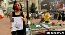 陈宝莹(手持传单者)6月25日七一前最后一个周末,在铜锣湾摆街站,呼吁市民关注一国两制。 (美国之音 汤惠芸)