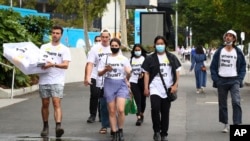 资料照片:人们在墨尔本举行的澳大利亚网球公开赛决赛前穿着“彭帅在哪里?"T恤衫。(2022年1月29日)