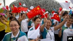 资料照:在北京奥林匹克体育场外,人们庆祝北京成功申办2022年冬季奥运会。(2015年7月31日)