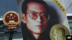 在香港中联办外,一名抗议者举着刘晓波的画像要求释放刘晓波