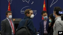 美国纽约时报驻北京记者史蒂文·李·迈尔斯(左)在参加中国外交部例行记者会后与其他外国记者聊天。(2020年3月18日)