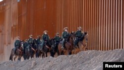 资料照片:美国边境巡逻队在埃尔森特罗(El Centro)区美墨边境围墙下的的一支骑警分队(2018年10月26日)