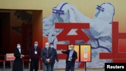 世卫组织新冠病毒源头调查组走出“武汉封城抗疫展览厅” (照片来自路透社,2021年1月30日)