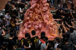 香港大学的学生在清理为悼念六四死难者而树立的“国殇之柱”。(2021年6月4日)