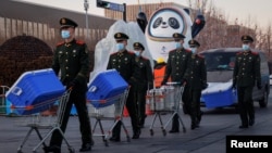 中国武警士兵在北京的冬奥会吉祥物前走过。(2022年1月15日)