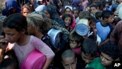 2024年10月17日,巴勒斯坦人在加沙地带代尔巴拉赫排队领取食物。(美联社照片)