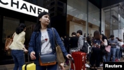 资料照片:在香港一处豪华购物区外等待的中国大陆游客。(2015年3月19日)