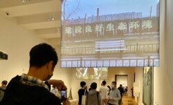 民主派前油尖旺区议员陈嘉朗(拿手机者)在M+博物馆参观艾未未录像作品《长安街》,他认为艺术品不应与国家安全扯上关系 (美国之音/汤惠芸)