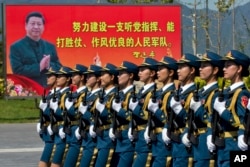 2015年8月22日,中国女兵在练习中走过标语牌