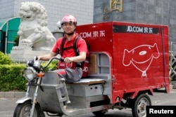 中国电子商务公司京东的首席执行官兼创始人刘强东2014年6月16日在北京开电动三轮车为客户送货,这是为了纪念公司成立日。